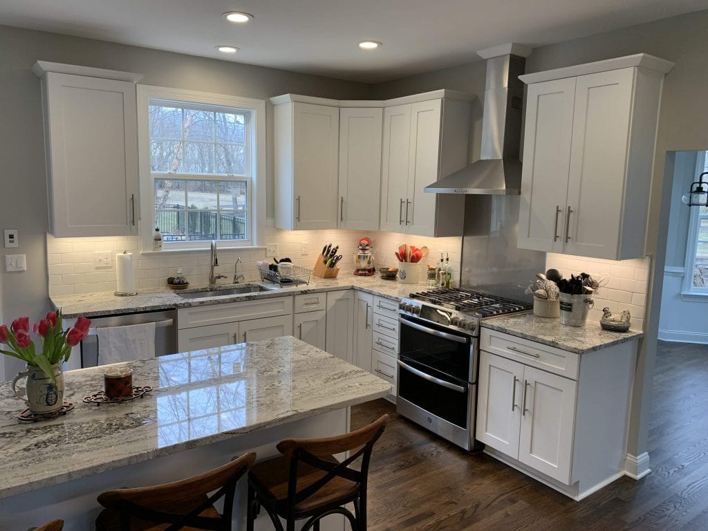 kitchen with black and white marbled counters and white cabinets
